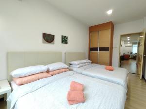 古晋Eden 8pax 3Rooms apartment near Kuching Airport的卧室内的两张床,配有粉红色枕头