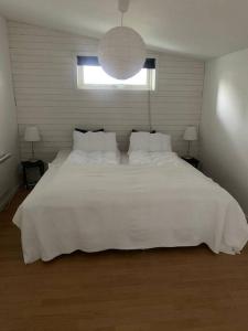 HerrekvarnHoliday home, by lake Simsjön and mountain Billingen的卧室内的一张大白色床,带有窗户