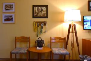 Großalmerode佐姆迦登斯蒂姆酒店的一间设有两把椅子、一张桌子和一盏灯的房间
