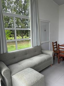 科洛尼亚-德尔萨克拉门托Complejo Las Palmeras的带沙发和大窗户的客厅