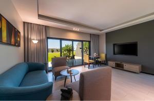 阿可贺巴HDB Al Khobar Resort & Spa的客厅配有蓝色的沙发和电视
