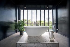 曼谷MIQ Ekkamai2 3BR Designer home Oval Bathtub 15pax的窗户客房内的大浴缸