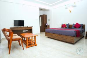 苏丹巴特利Le Eden Resort的卧室配有1张床、1张桌子和1把椅子