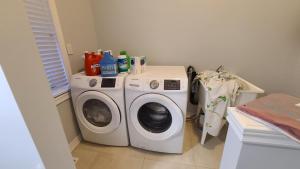 坎布里奇LUXURY 2-BEDROOMS UNIT WITH WIFI, LDR & PARKING.的小房间里的洗衣机和烘干机