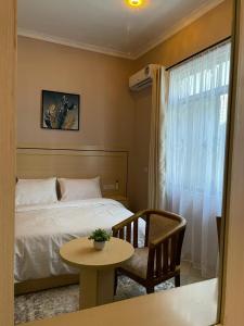 多多马Rosa Hotels的卧室配有1张床、1张桌子和1把椅子