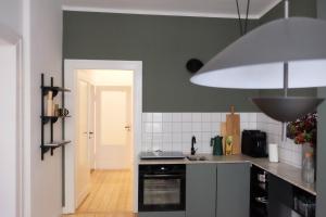 魏玛Design Apartments Weimar Altstadt的厨房配有水槽和炉灶 顶部烤箱