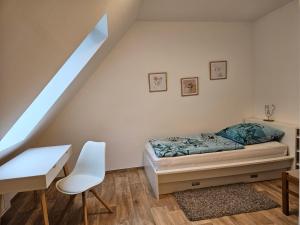 沃尔夫斯堡3 Zimmerwohnung am Neuer Teich的一间卧室配有一张床、一张书桌和一个窗户。