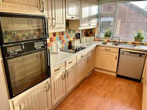 切斯特勒斯特里特Beautiful 3-Bed House in Chester-le-Street的厨房配有白色橱柜和黑色冰箱。