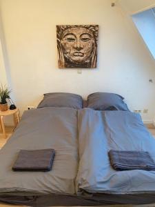 奥斯纳布吕克Stilvolle helle Wohnung im Zentrum的一张带两个枕头的床和墙上的绘画