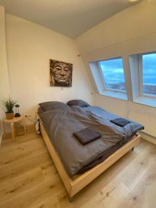 奥斯纳布吕克Stilvolle helle Wohnung im Zentrum的一张大床,位于带两个窗户的房间