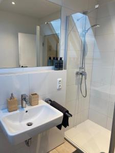 奥斯纳布吕克Stilvolle helle Wohnung im Zentrum的白色的浴室设有水槽和淋浴。