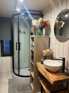 Smiltsērkšķu namiņš的带淋浴和白色盥洗盆的浴室