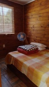 德尔迪阿布罗角Cabañas azules的一间卧室配有一张带风扇的床