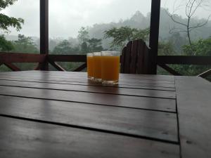 代尼耶耶Sinharaja Forest Gate的木桌旁的一杯橙汁