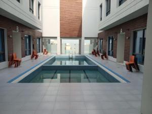 阿尔科兰Al Salam Resort的一座带椅子的建筑中央游泳池