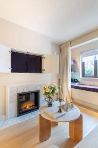 伦敦Spring Stays Cosy 2-Bed Residence with Free Parking的客厅设有壁炉和桌子