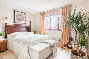 伦敦Spring Stays Cosy 2-Bed Residence with Free Parking的一间卧室设有一张大床和一个窗户。
