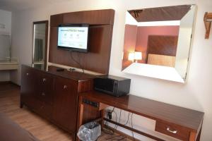 CollinsvilleRelax Inn的客房设有一张带电视和镜子的书桌
