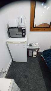 查塔姆Cosy and Relaxing的厨房配有冰箱上方的微波炉