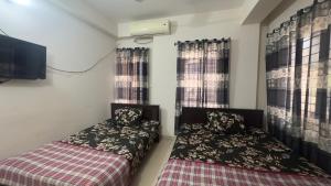 达卡Appayan Guest House (Baridhara)的小型客房设有2张床和窗户。