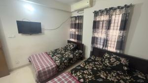 达卡Appayan Guest House (Baridhara)的一间卧室配有一张床和一台平面电视