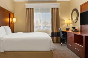 萨吉诺萨吉诺康福特套房酒店的配有一张床、一张书桌和一扇窗户的酒店客房