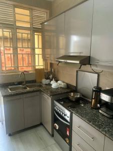 基加利ADRIEL HOMES KIGALi的厨房配有炉灶和水槽。