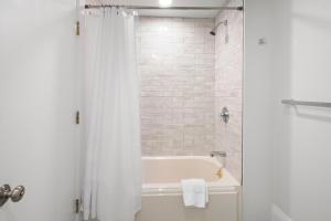波士顿Charlesgate Suites的白色的浴室设有浴缸和淋浴。