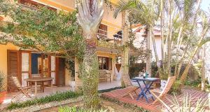 弗洛里亚诺波利斯Maison de La Mer 300m da praia的一座配有桌椅和棕榈树的房子