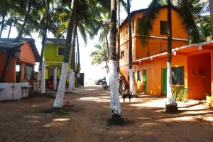 马尔万KonkanParadise,Hotel Malvan Beach的一组棕榈树,位于一座建筑旁边