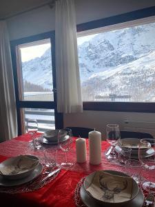 布勒伊-切尔维尼亚Ski paradise - Cielo alto Cervinia的一张桌子,上面有红桌布和酒杯
