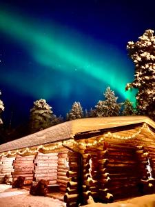 普哈圣山Arctic Lodges Lapland Ski in, slopes, ski tracks, National Park, free Wi-Fi - Lapland Villas的天空中光辉灿烂的冰屋