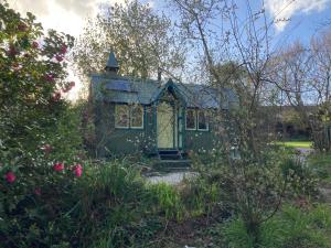 布德Enchanting Hand Painted Tabernacle with Hot Tub的玫瑰园里的一个绿色小房子