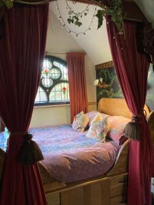 布德Enchanting Hand Painted Tabernacle with Hot Tub的一间卧室配有带窗帘的床和窗户