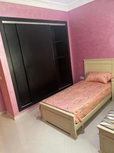 得土安Appartement De Luxe A Wilaya De Tetouan的一间卧室配有一张床和粉红色的墙壁
