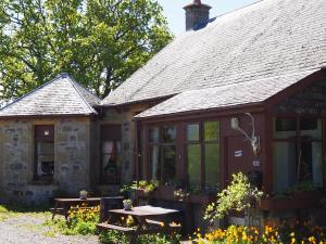 金尤西Uist Cottage的前面有一张野餐桌的房子