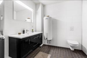 Modern 2-bedroom apartment的白色的浴室设有卫生间和水槽。