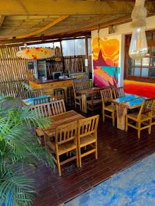 费尔南多 - 迪诺罗尼亚Coral azul Noronha的餐厅的门廊上设有木桌和椅子