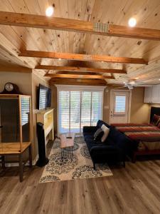 Lake AlfredThe Lake Alfred Citruswood Cabin的客厅配有床、沙发和电视
