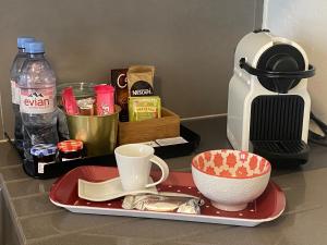 日内瓦HOCORAS Apartment的咖啡冲泡器和杯子的红盘