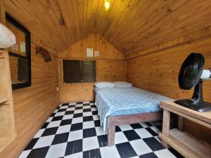 蜜岛克洛铎露营旅馆的木制客房内的一间卧室,配有一张床