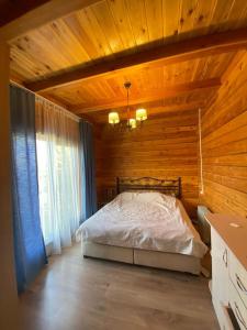 Chon-Sary-OyСруб на Иссык Куле的木制客房内的一间卧室,配有一张床