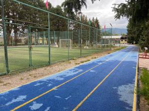 Chon-Sary-OyСруб на Иссык Куле的一座带围栏的空篮球场和一个网球场