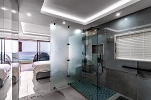 巴利托Modern Chic Beachfront Apartment的带淋浴的浴室和1间带1张床的卧室
