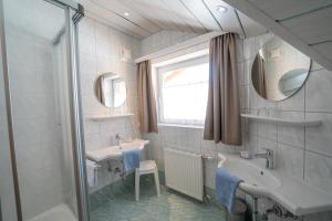 拉德施塔特科斯雷尔旅馆的一间带水槽、镜子和淋浴的浴室