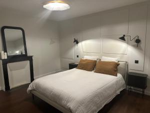 韦尔图La Casa Samat的一间卧室配有一张带白色床单和镜子的床