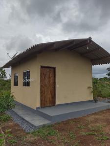 戈亚斯州上帕莱索Chalé pôr do Sol的田野上一扇棕色门的小房子