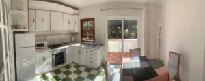 拉奥罗塔瓦Casa Laura的厨房配有白色橱柜和 ⁇ 格地板