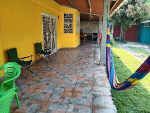 San Pedro MasahuatCasa para descanso familiar的黄色房子前面带吊床的庭院