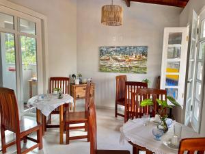 伊尔哈德博伊巴Pousada Divina Vila的一间带桌椅的用餐室和一幅画